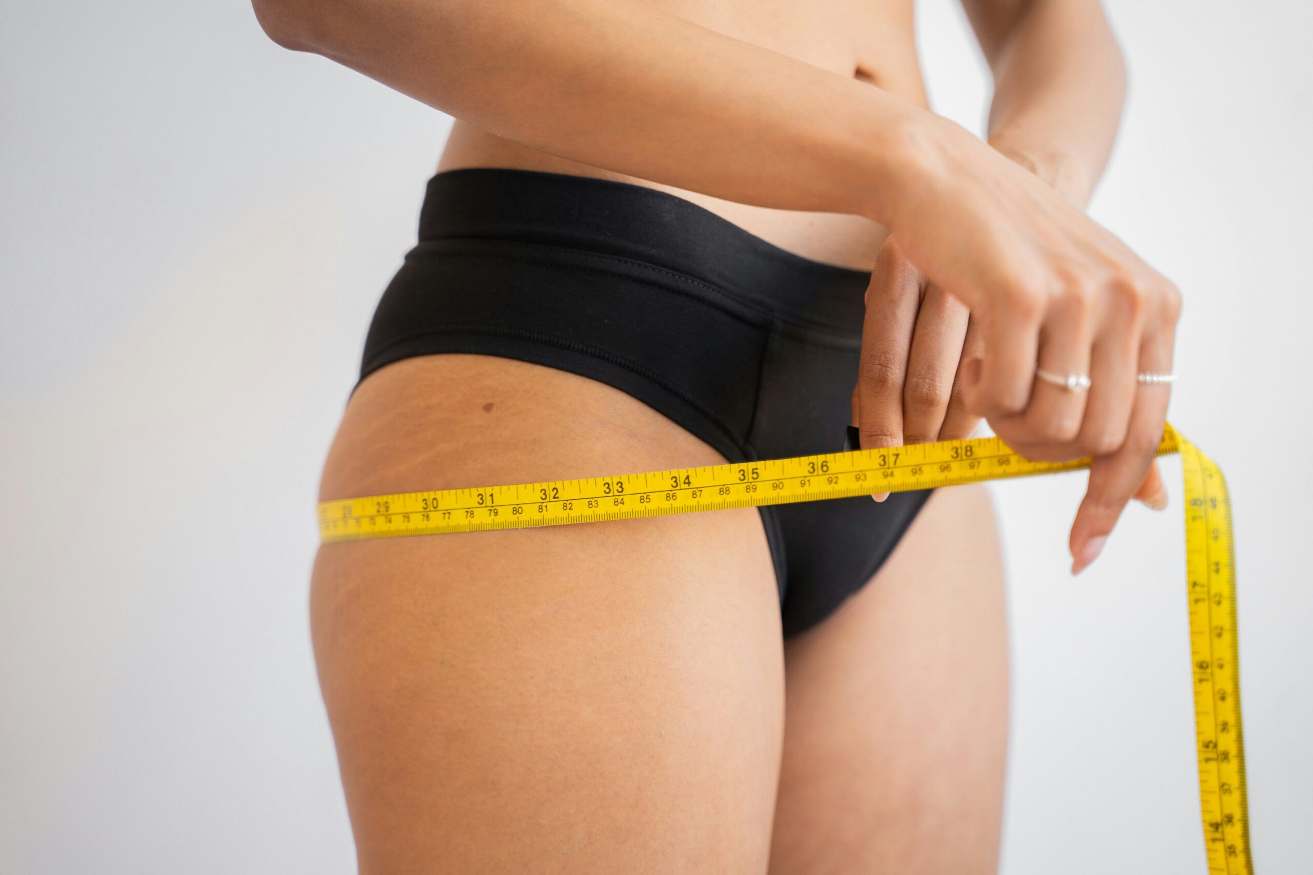 women measuring herself after dieting attempts